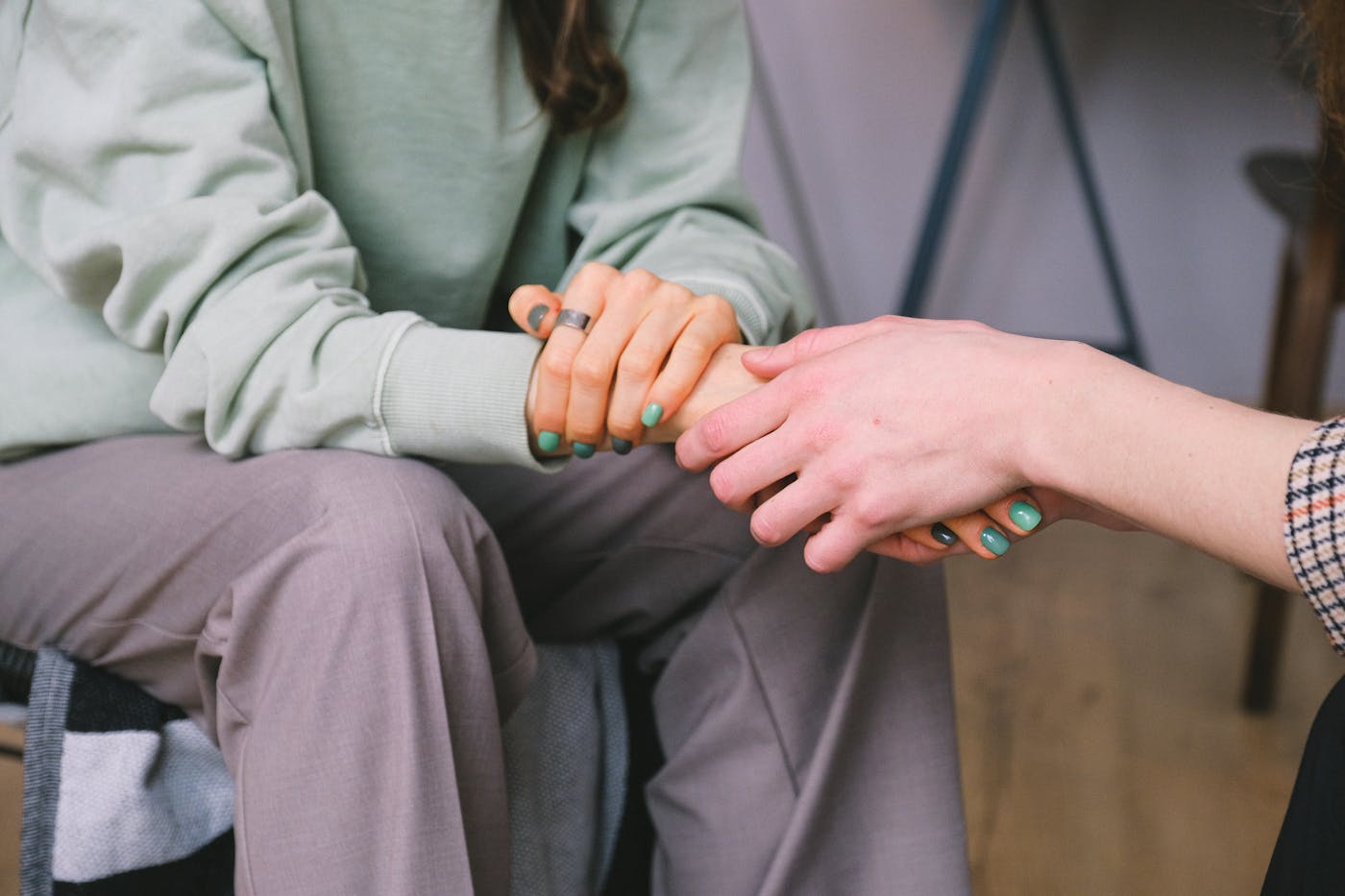 Two people clasping hands in a moment of reassurance and support