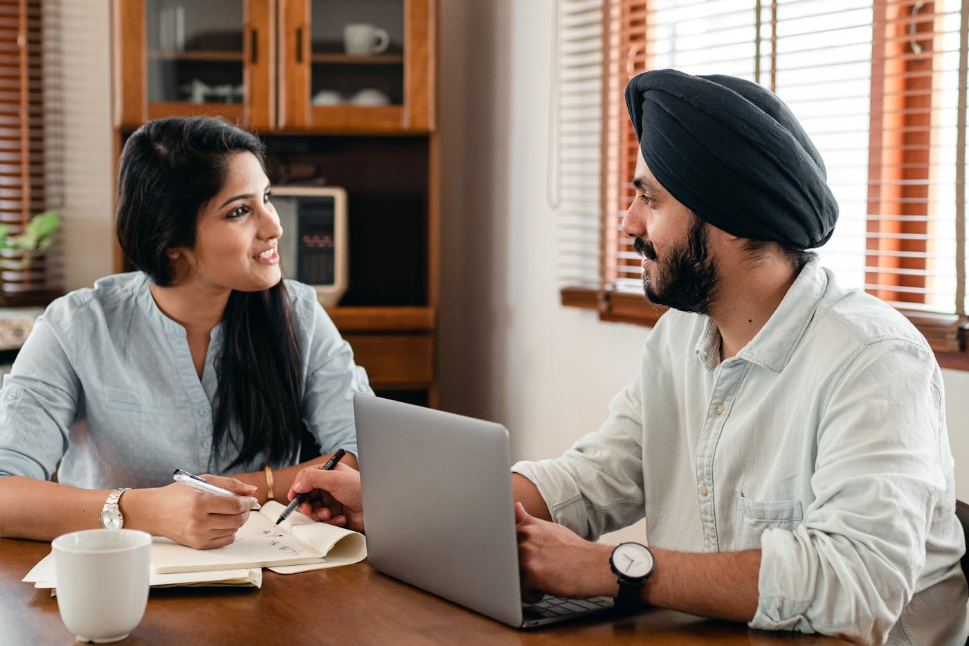 Two people preparing notes together at a kitchen table